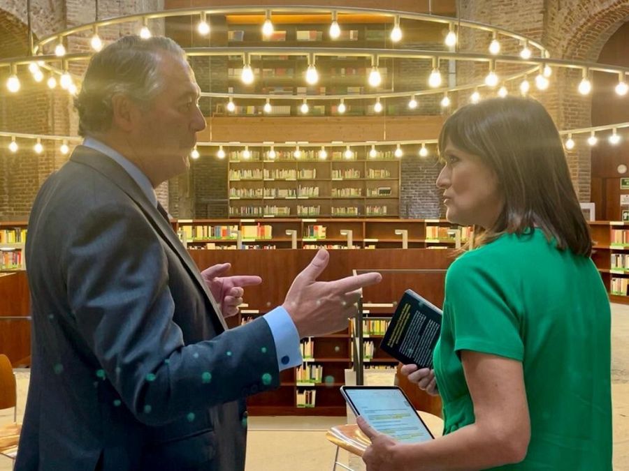 Jose María Michavila conversa con Diana Arias envueltos en una luz amarillenta.