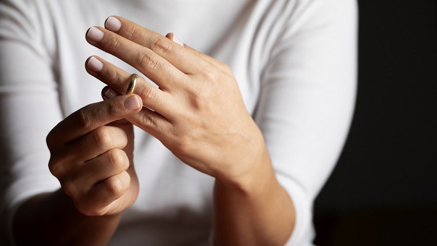 Una mujer se quita el anillo de casada