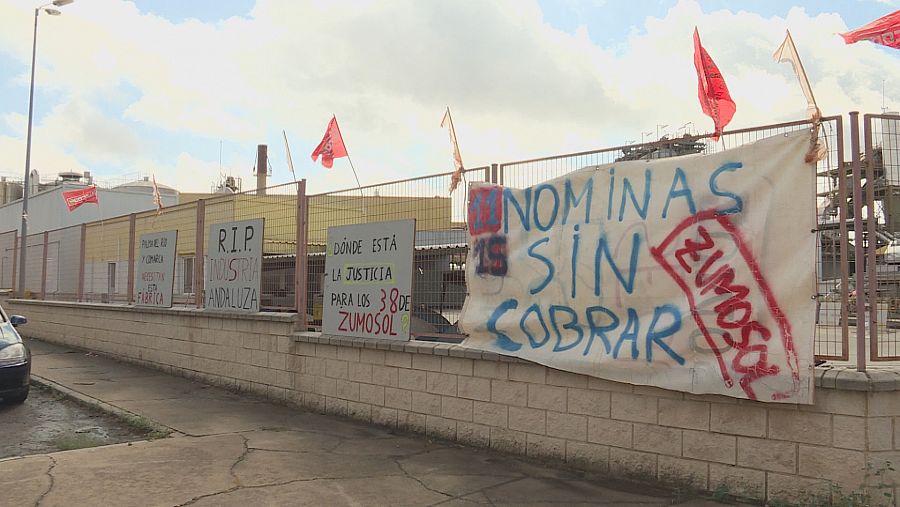 Pancartas contra Cegeplas y Zumos Palma en la valla de la antigua fábrica Zumosol de Palma del Río