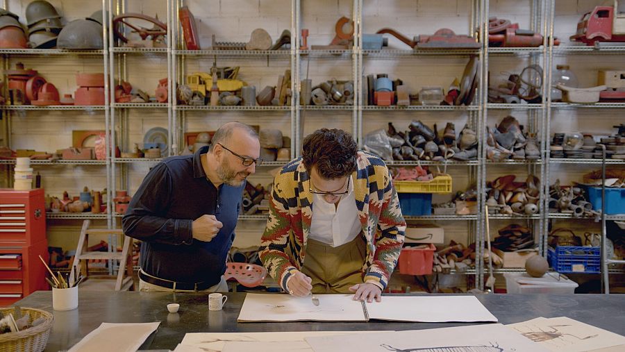 Juan Avellaneda practicant dibuixar amb cafè amb Miquel Aparici al seu taller,  a 'Fet a mà'