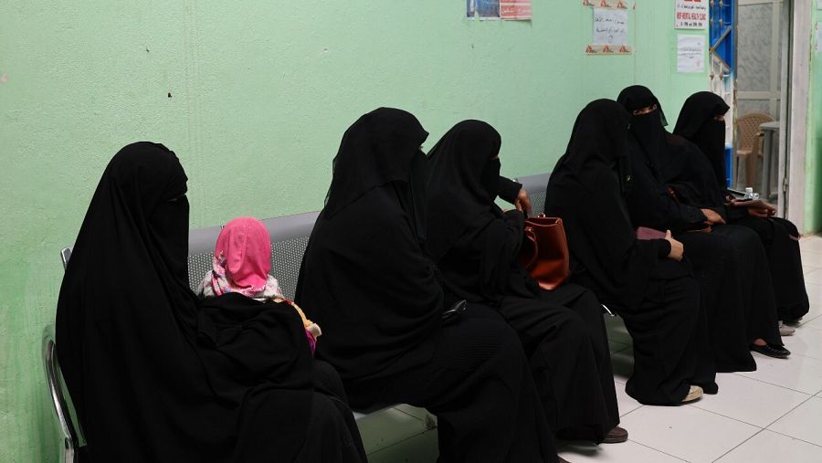 Un grupo de mujeres con burkas negros espera en la consulta del médico