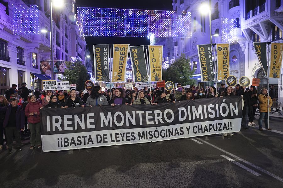 Participantes de la marcha piden la dimisión de la ministra Irene Montero con una pancarta que dice  