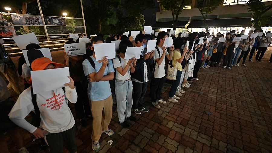 Estudiantes de la Universidad China de Hong Kong se manifiestan con carteles y folios en blanco en solidaridad con las manifestaciones contra las medidas por la COVID en otras partes de China. Foto: Peter PARKS / AFP