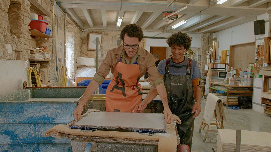 Juan Avellaneda, acompanyat de Jordi Torrent, fent paper de manera artesanal al taller