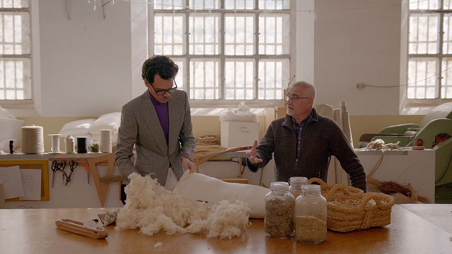 Carles Casas, amb Juan Avellaneda, al seu taller mostrant els teixits amb els que fa els matalassos