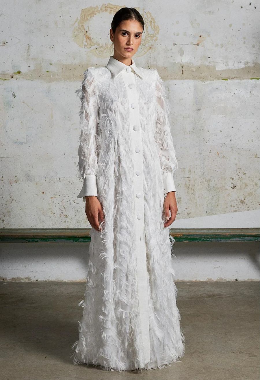 Un abrigo con un vestido de satén debajo es una opción perfecta para novias que se casan en invierno
