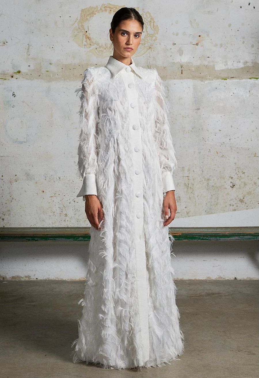 Un abrigo con un vestido de satén debajo es una opción perfecta para novias que se casan en invierno