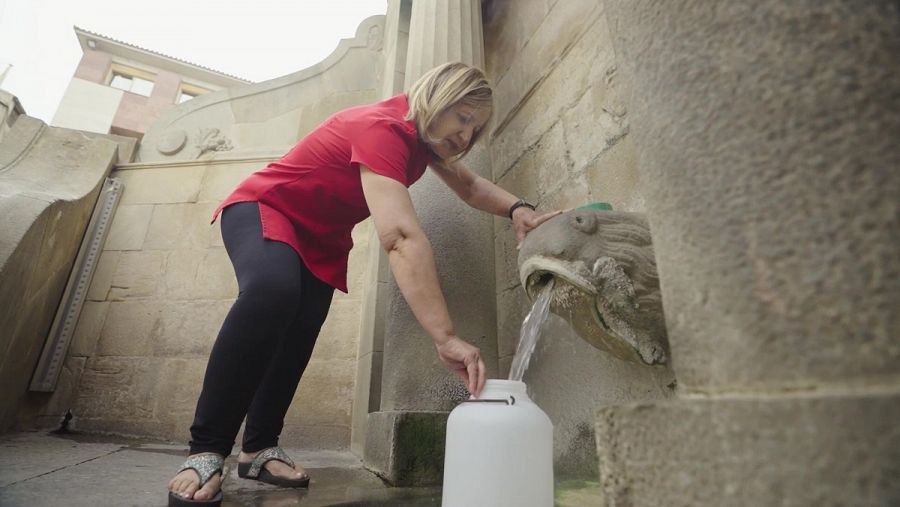 Una veïna de Caldes de Montbui agafa aigua de la Font del Lleó