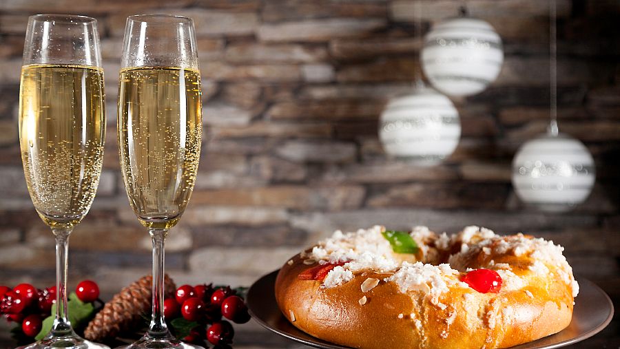 Un roscón de Reyes junto a dos copas rellenas de champagne