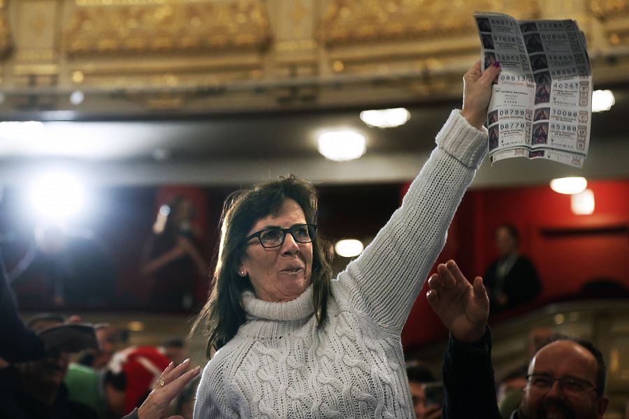 Una mujer del público celebra ser portadora de un quinto premio durante el sorteo de Navidad celebrado en el Teatro Real en Madrid