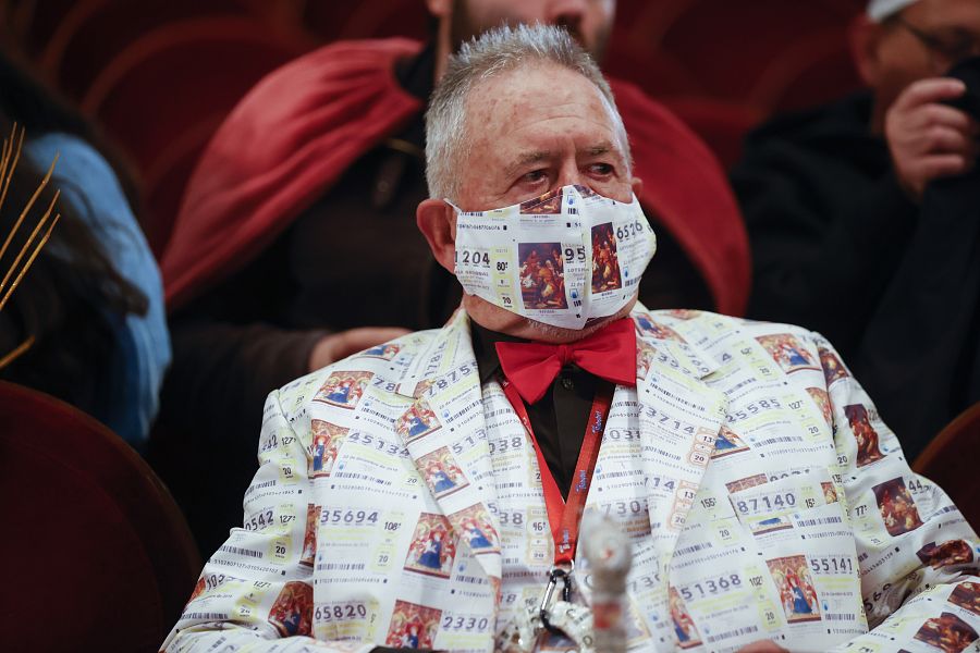 Un hombre ataviado con un traje estampado con décimos de lotería en el Teatro Real en Madrid