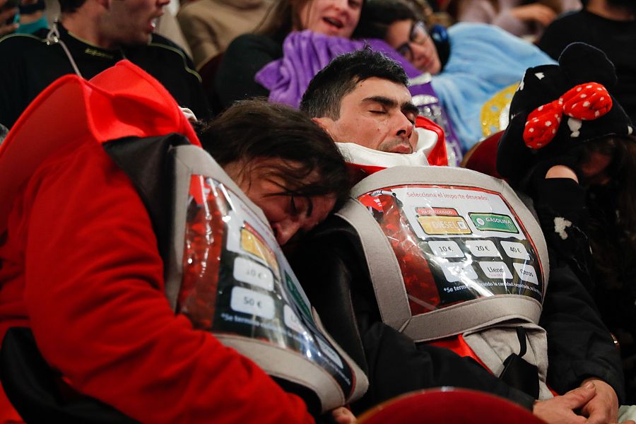 Dos personas disfrazadas duermen durante el sorteo de la Lotería de Navidad en el Teatro Real