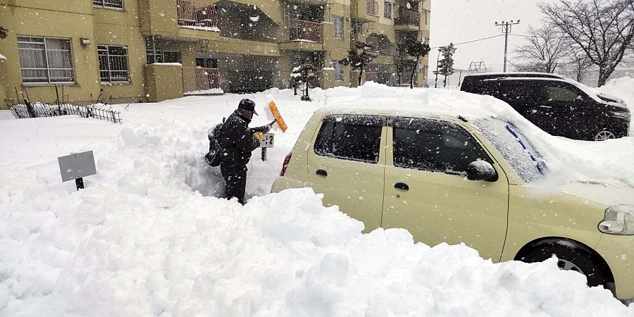 Un hombre limpia la nieve en un aparcamiento en Kitami, prefectura de Hokkaido, Japón.