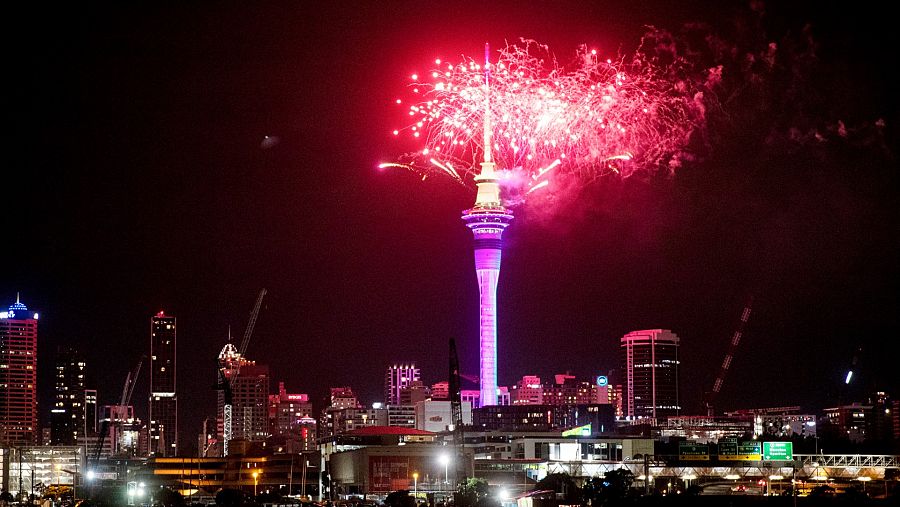 Fuegos artificiales explotan sobre Sky Tower en el centro de Auckland al comenzar las celebraciones de Año Nuevo en Nueva Zelanda