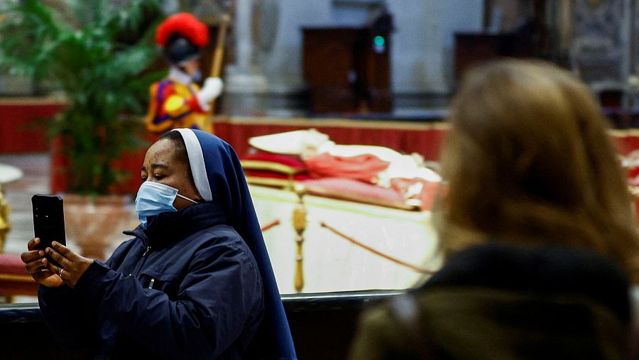 Una religiosa se toma una fotografía en la capilla ardiente de Benedicto XVI