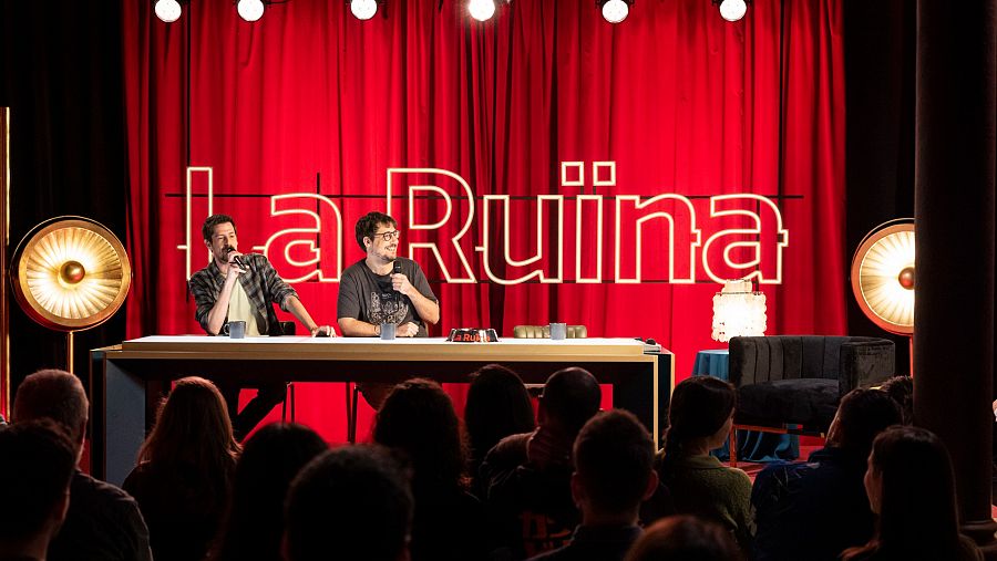 Ignasi Taltavull i Tomàs Fuentes asseguts darrere una taula amb els micròfons fent 'La ruïna'