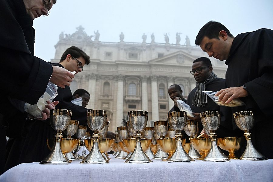 Varios clérigos preparan la Ecucaristía antes de la ceremonia fúnebre por el papa emérito