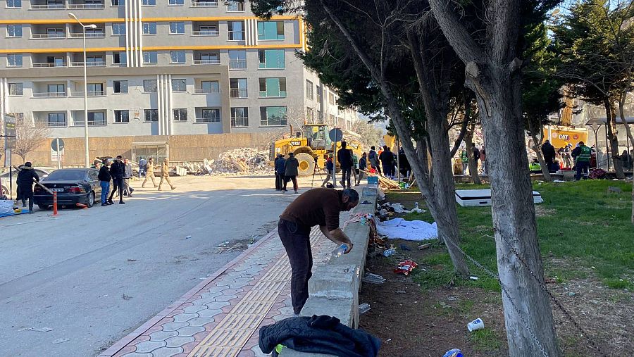 Un hombre coge agua de un grifo en un parque
