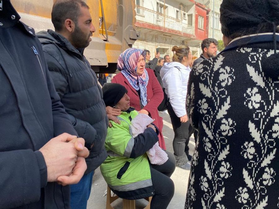 Una mujer llora mientras observa cómo sacan un cuerpo de un edificio derrumbado en Iskenderun
