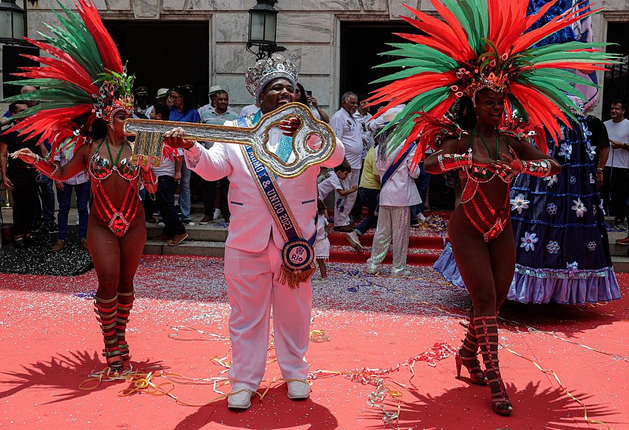 El Rey Momo, acompañado por pasistas de carnaval, posa con la llave de la ciudad en Río de Janeiro