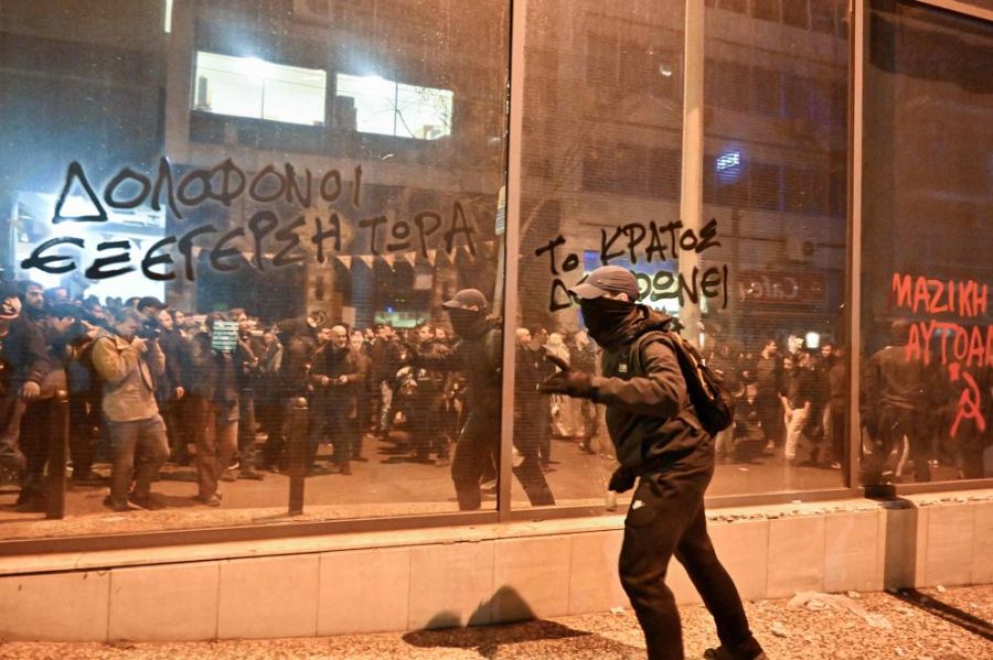 Un manifestante huye de la policía frente a la sede del Hellenic Train donde se ha convocado una protesta.