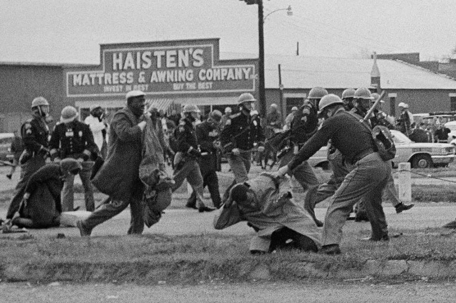 Un policía estatal de Alabama golpea con una porra a John Lewis, a la derecha, en la marcha por los derechos civiles en Selma, Alabama en 1965.