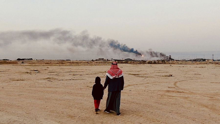 Padre e hijo en Zubair con los pozos de petróleo al fondo