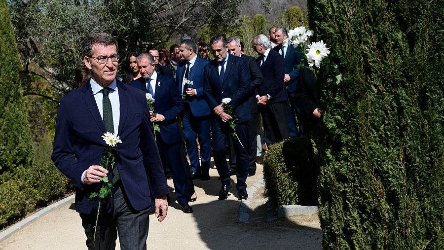 El líder del PP, Alberto Núñez Feijóo, coloca una flor blanca en memoria de las víctimas del 11M.