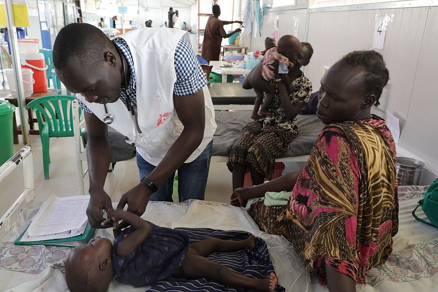 Trabajador humanitario MSF con un niño y su madre
