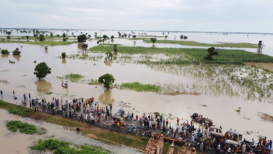  La gente camina por tierras de cultivo inundadas después de fuertes lluvias en Hadeja, Nigeria