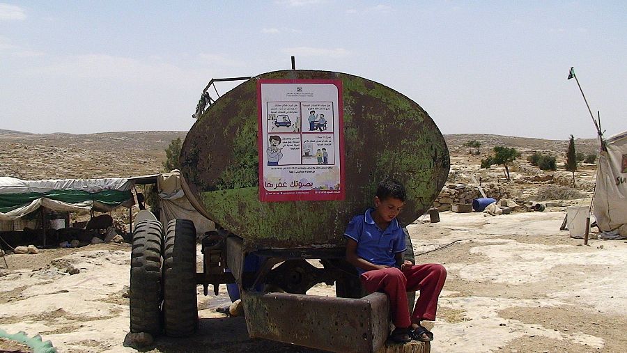  Un niño junto a un tanque de agua en la localidad cisjordana de Susia, en las colinas del sur de Hebrón (Cisjordania). 22/08/2012