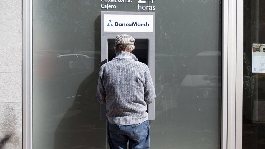 Un hombre retira dinero de un cajero automático