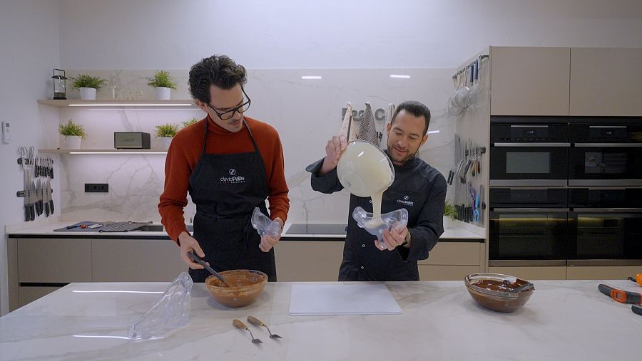 Juan Avellaneda a la cuina del xocolater David Pallàs, qui està posant xocolata blanca en un motlle