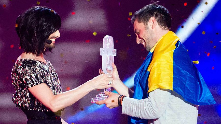 Conchita Wurst, ganadora de Eurovisión 2014, entrega el micrófono de cristal a Måns Zelmerlöw, ganador de Eurovisión 2015