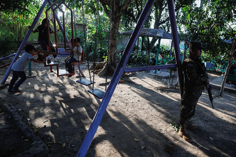 Un soldado vigila un parque de una colonia en el que ahora vuelven a jugar los niños