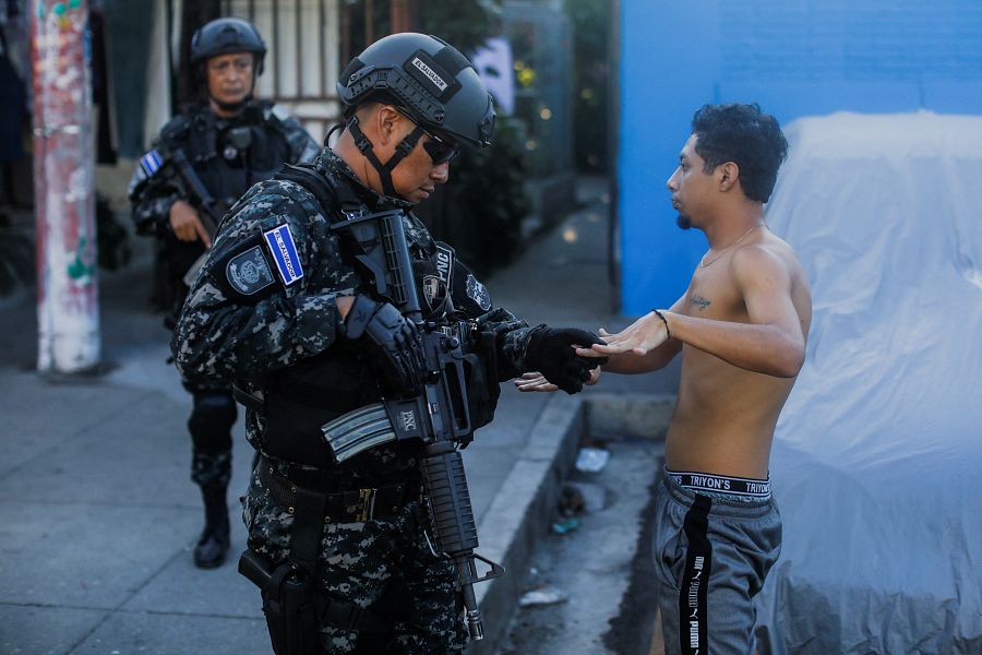 Un policía registra a un joven en una calle del barrio de Las Margaritas durante una patrulla antipandillas