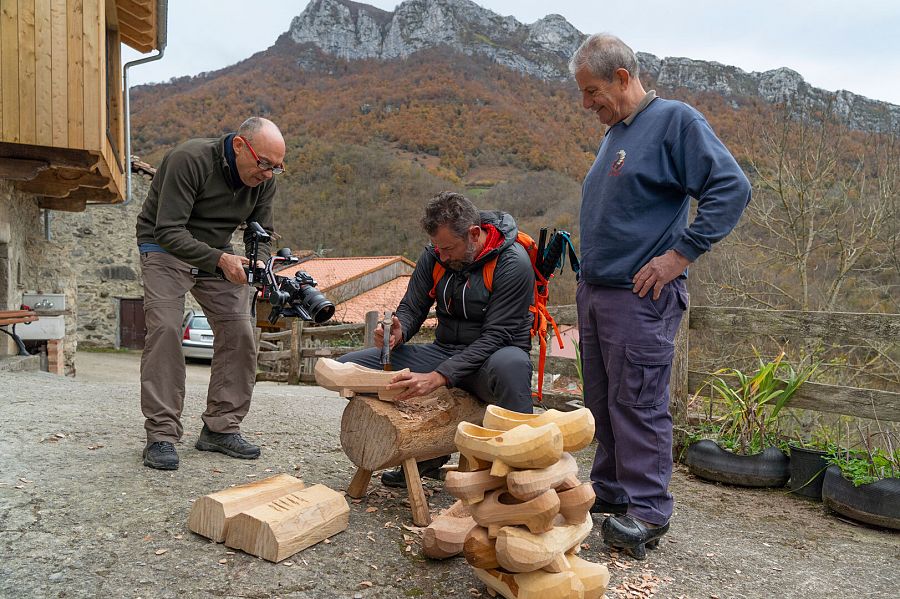 Juan Lozano, el último madreñero de Bezanes, enseña al presentador de 80 cm, algunos de los conocimientos básicos para hacer las madreñas