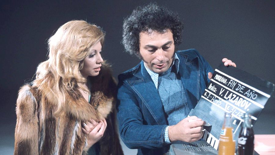 Valerio Lazarov junto a la cantante Karina, en plató observando una claqueta con el nombre del realizador