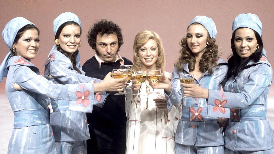 Las bailarinas y cantantes del programa Señoras y Señores, vestidas de azul, posan junto al realizador del espacio, Valerio Lazarov