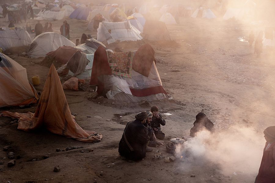 Una familia quema plástico para tener un fuego con el que cocinar en un campamento a las afueras de Herat.