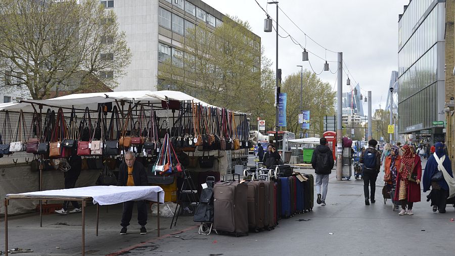 Un grupo de mujeres pasea al lado de un puesto en el barrio londinense de Tower Hamlets