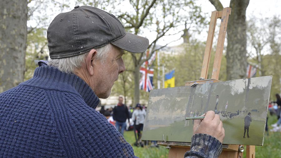 Un hombre pinta un cuadro en el parque de St. James