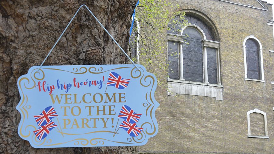 Un cartel en el jardín de la iglesia de St. james anuncia una fiesta para celebrar la coronación de Carlos III