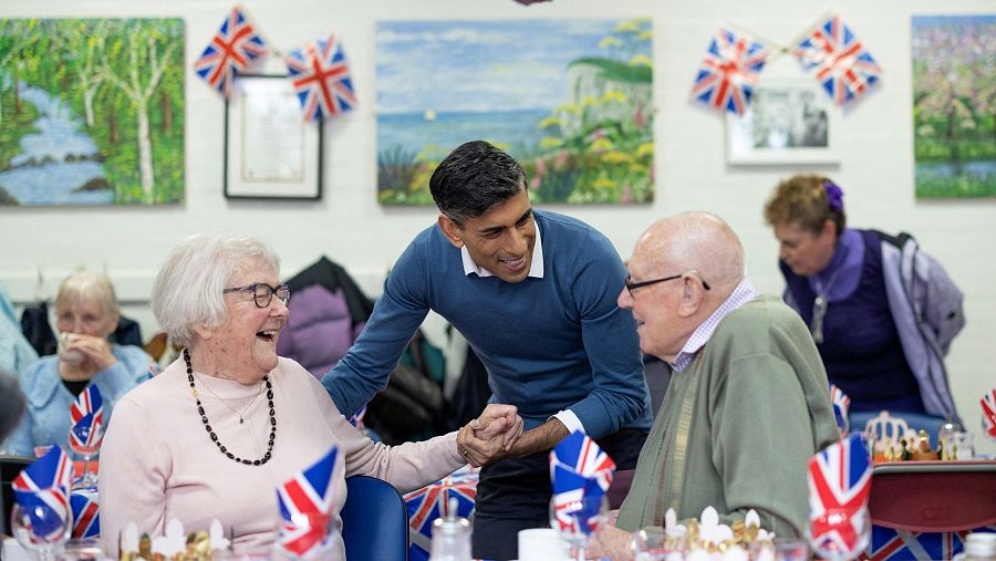 El primer ministro británico habla con la gente durante su visita a un comedor de mayores