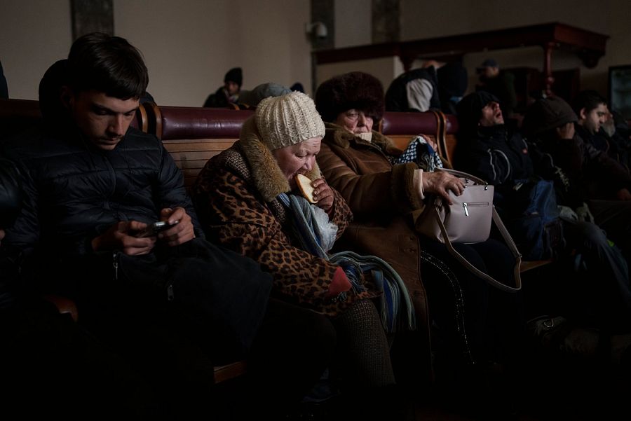 Una anciana ucraniana come una rebanada de pan en el interior de una abarrotada estación de tren en Lviv, al oeste de Ucrania.