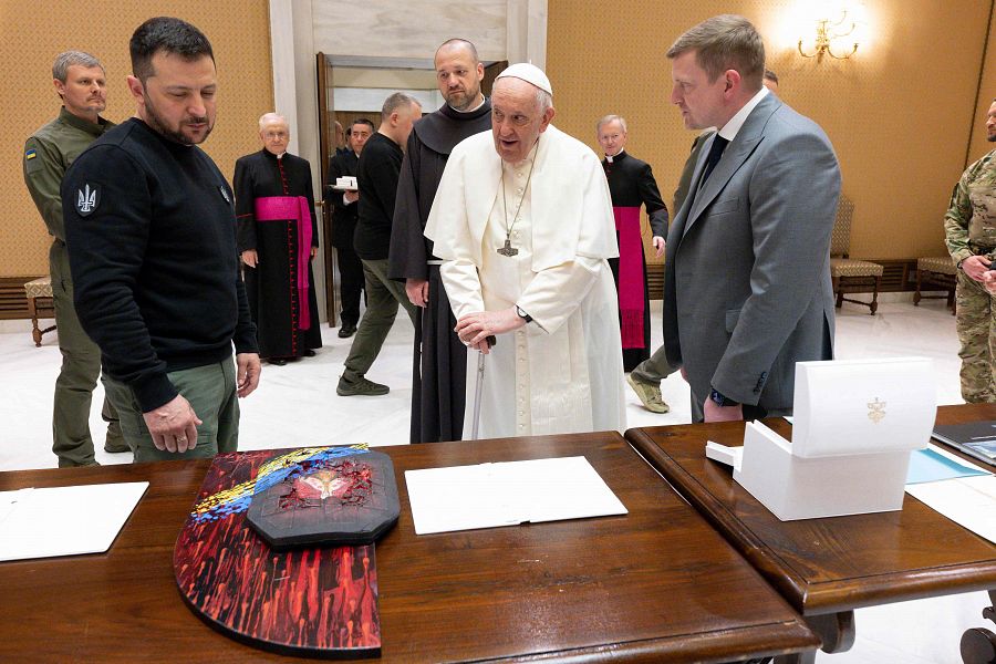El papa Francisco (C) y el presidente ucraniano Volodímir Zelenski (I) intercambiando regalos tras una audiencia privada en el Vaticano.
