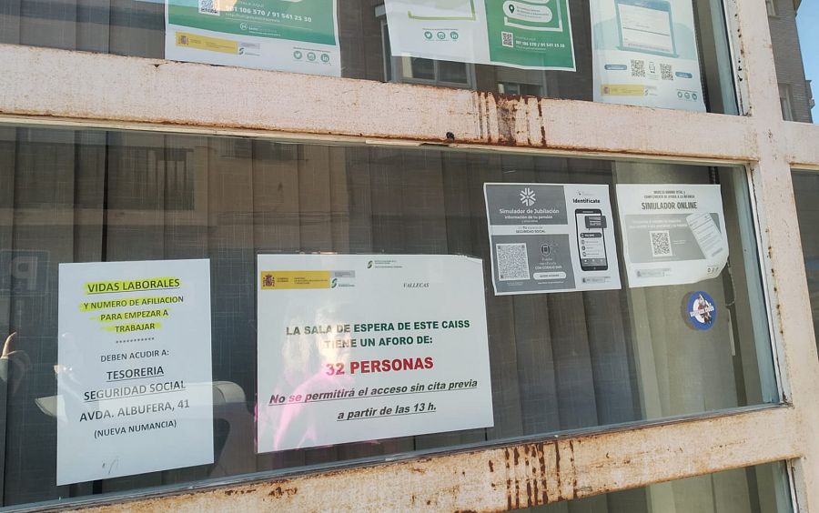 Un cartel informa sobre la cita previa en la oficina de la Seguridad Social de Vallecas, Madrid