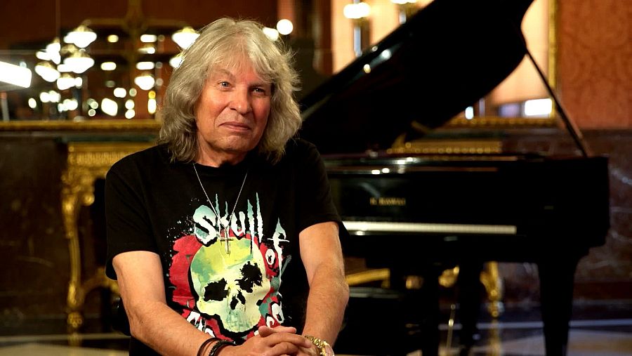 José Mercé con su característica melena canosa y una camiseta negra.