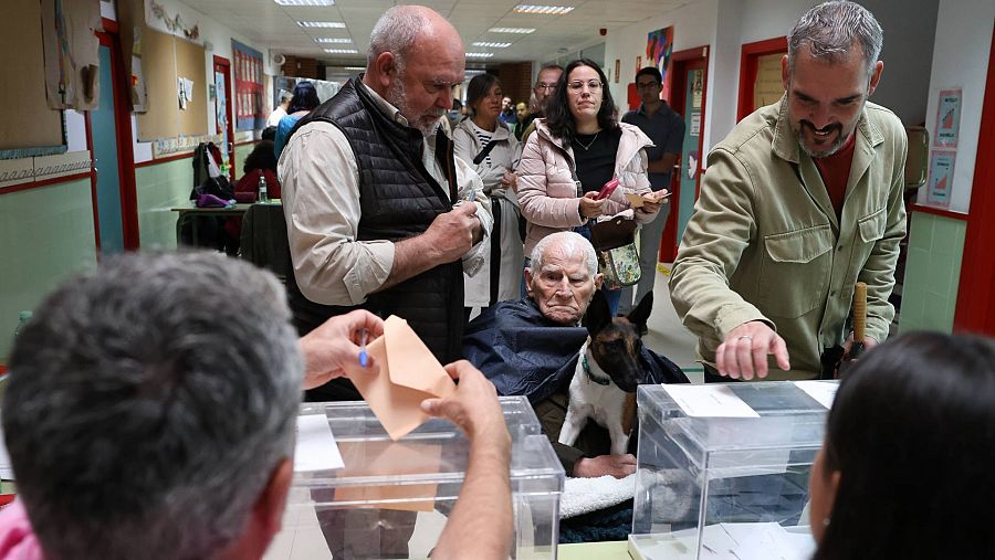 Varias personas ejercen su derecho al voto en el Colegio Público Chozas de la Sierra (Madrid)