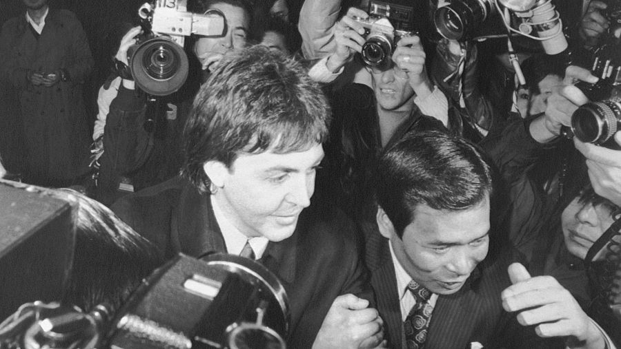 Paul McCartney rodeado de fotógrafos, accede a la sala de control de estupefacientes del aeropuerto de Narita, Tokio
